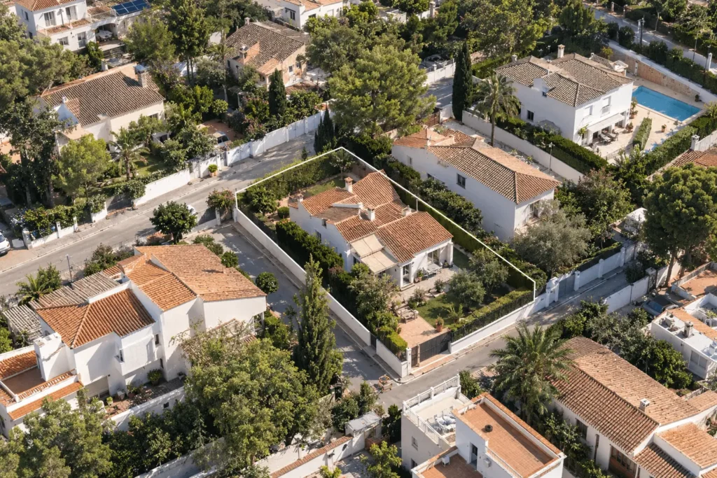 Vista aérea de viviendas con una parcela delimitada para ilustrar qué es el Catastro.